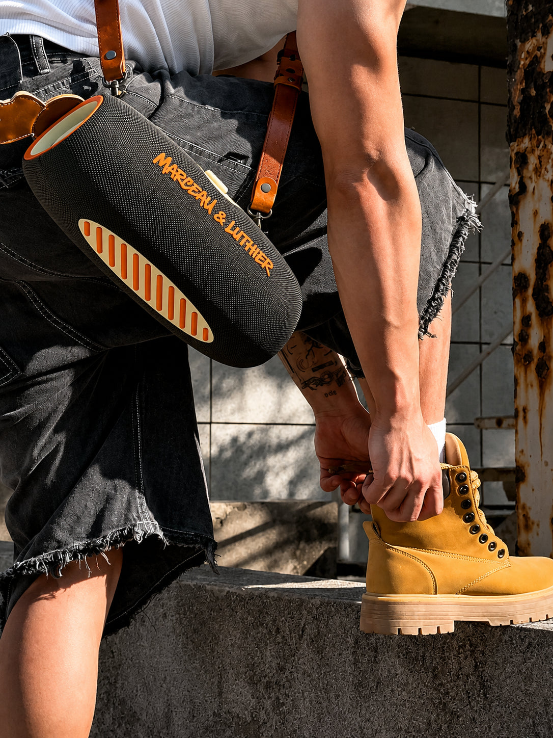 Model standing on industrial step with the Rive Droite speaker, blending high-end audio with urban street style.